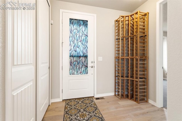 entryway featuring light wood-type flooring, baseboards, and visible vents