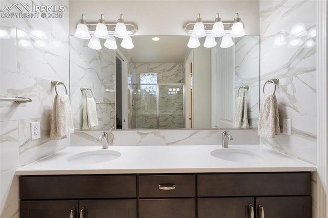 bathroom with recessed lighting, a sink, a marble finish shower, and double vanity