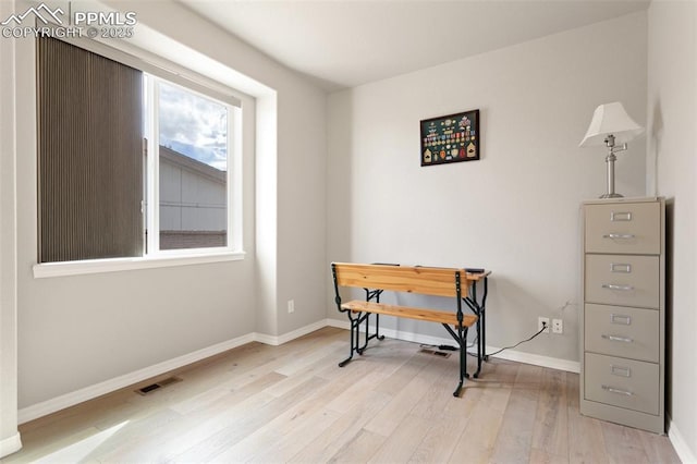 home office featuring baseboards, visible vents, and light wood finished floors