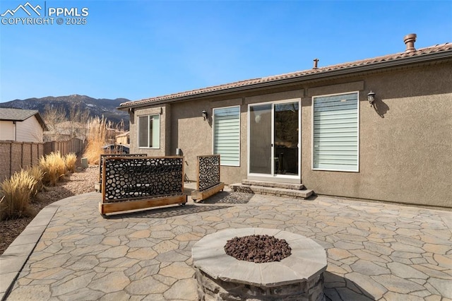 rear view of property featuring a patio, fence, and stucco siding