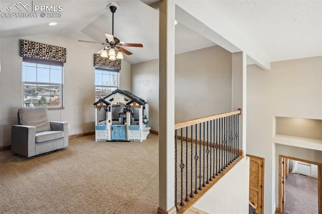 living area featuring carpet floors, vaulted ceiling, baseboards, and a ceiling fan