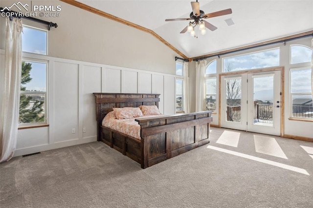 carpeted bedroom with access to exterior, multiple windows, visible vents, and a decorative wall