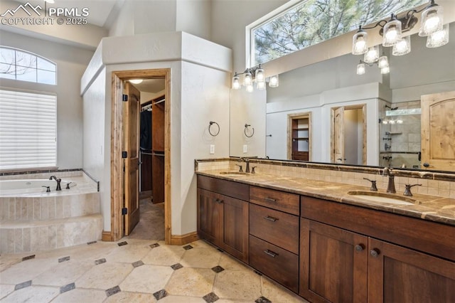 full bath with double vanity, decorative backsplash, a sink, a shower stall, and a bath