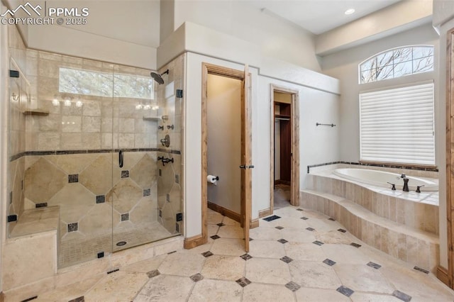 full bathroom with a stall shower, a garden tub, and baseboards