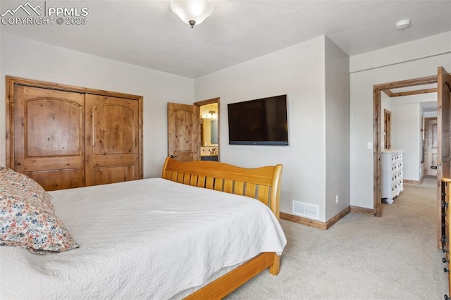 bedroom featuring baseboards, visible vents, connected bathroom, and light colored carpet