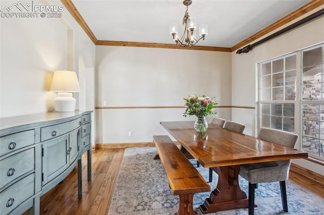 dining area with a chandelier, crown molding, and hardwood / wood-style flooring