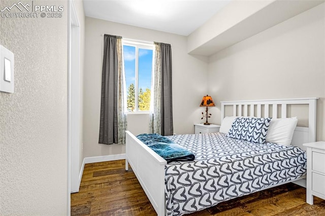 bedroom with wood finished floors and baseboards