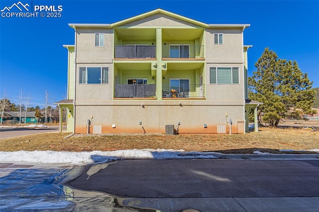 exterior space with stucco siding, central air condition unit, and a balcony