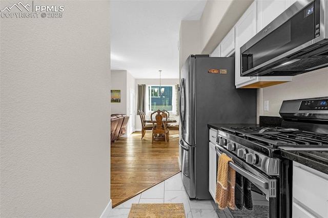 kitchen with dark countertops, white cabinets, and stainless steel appliances