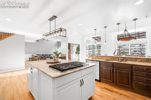 kitchen with stainless steel appliances, light wood-type flooring, white cabinets, and a sink