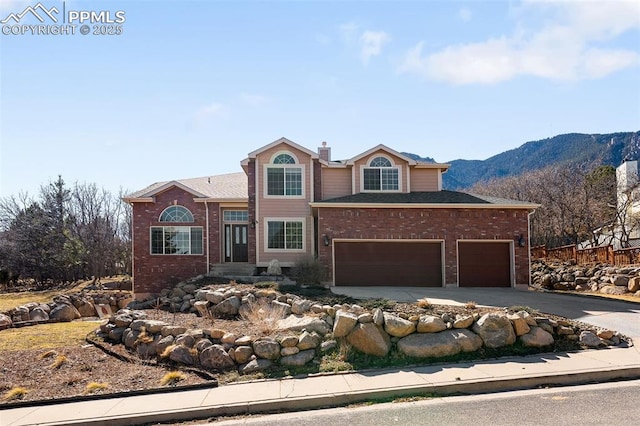 traditional home featuring a garage, aphalt driveway, a chimney, and brick siding