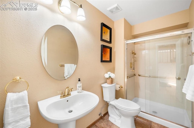 full bathroom featuring a stall shower, visible vents, toilet, tile patterned flooring, and a sink