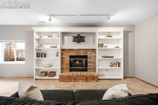 living area featuring built in shelves, a fireplace, and tile patterned floors