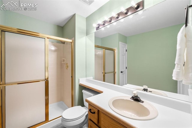 bathroom featuring visible vents, a stall shower, vanity, and toilet