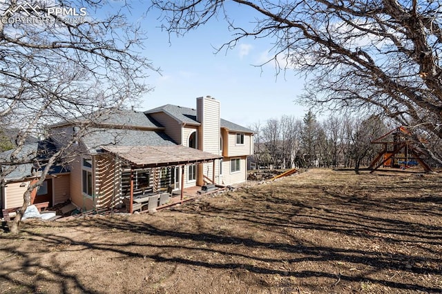 view of property exterior with entry steps, roof with shingles, a chimney, and a playground