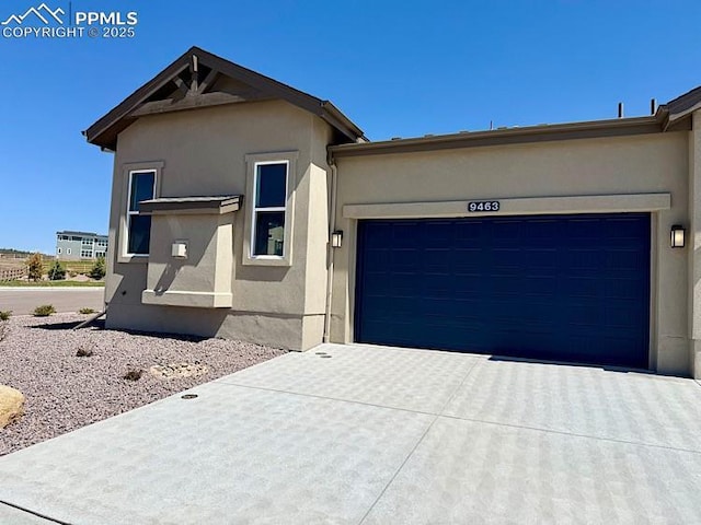 9463 Jollity Pt, Colorado Springs, CO 80924 - view of front of property with stucco siding, driveway, and an attached garage