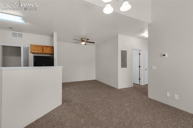 unfurnished living room featuring electric panel, visible vents, carpet floors, and ceiling fan