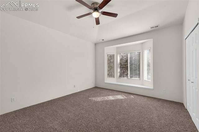 unfurnished bedroom featuring a closet, visible vents, a ceiling fan, and carpet