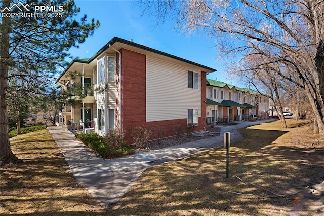 view of home's exterior with a residential view, a balcony, a porch, and brick siding