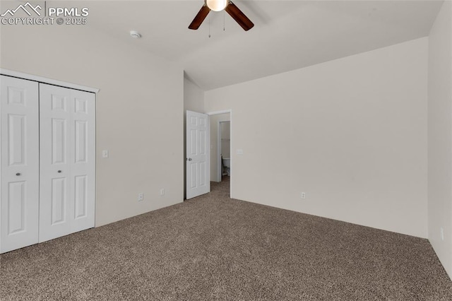 unfurnished bedroom featuring a closet, lofted ceiling, a ceiling fan, and carpet flooring