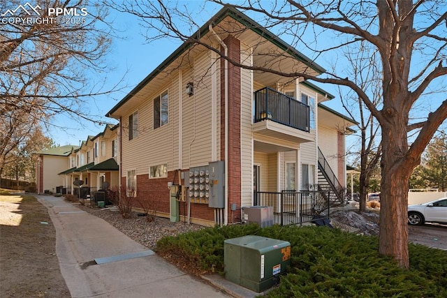 view of side of home featuring mail area and a balcony