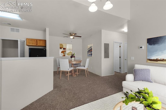 carpeted living room with electric panel, visible vents, and a ceiling fan