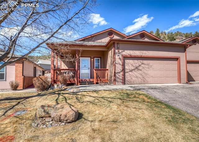 single story home with aphalt driveway, covered porch, and a garage