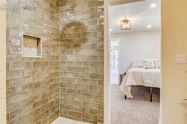 ensuite bathroom featuring recessed lighting, tiled shower, connected bathroom, and a textured ceiling