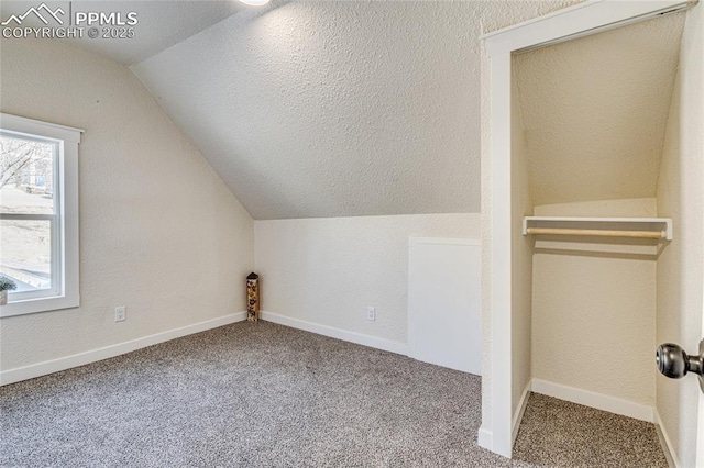 bonus room with a textured ceiling, carpet floors, lofted ceiling, and baseboards