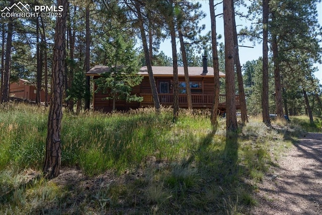 rear view of house with faux log siding and a wooden deck