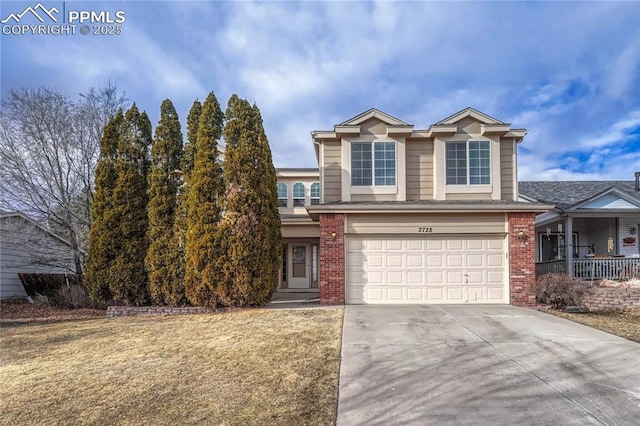 traditional-style home featuring a garage, concrete driveway, brick siding, and a front yard