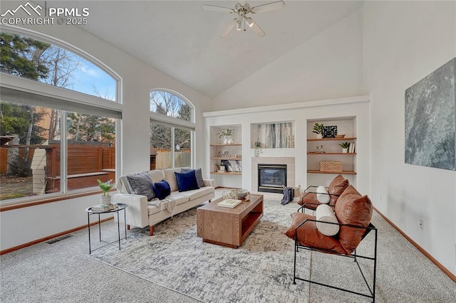 sunroom with visible vents, vaulted ceiling, a tiled fireplace, and ceiling fan