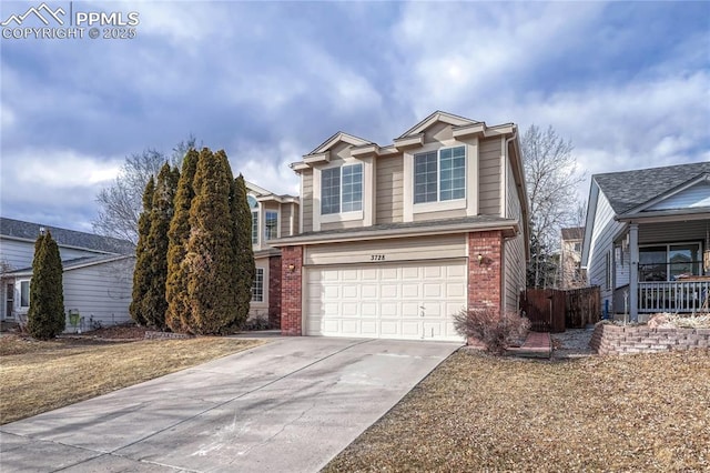 traditional home with a garage, brick siding, driveway, and fence