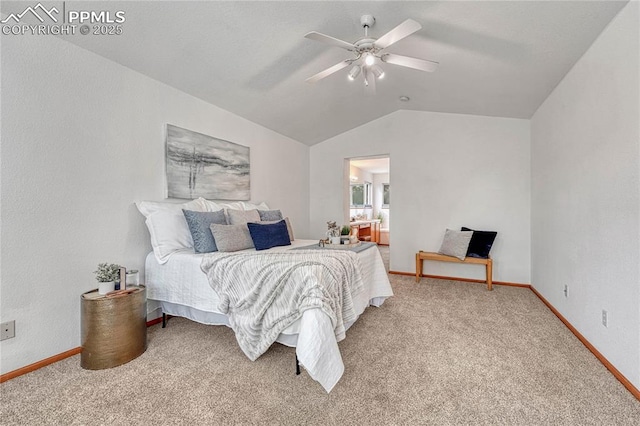 bedroom featuring light carpet, baseboards, ensuite bathroom, and lofted ceiling