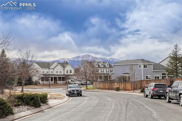 view of street featuring a residential view, curbs, sidewalks, and a mountain view