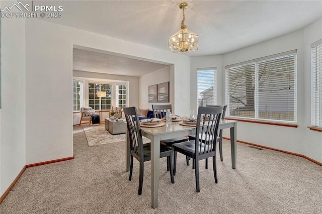 dining room with light colored carpet, visible vents, baseboards, and an inviting chandelier