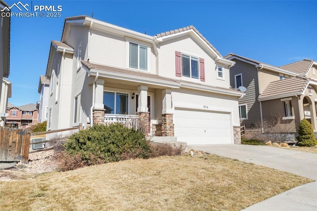 view of front of property with an attached garage, fence, stone siding, driveway, and stucco siding