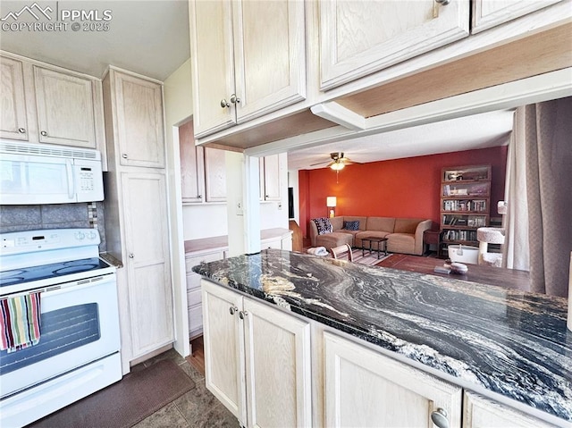 kitchen with open floor plan, ceiling fan, white appliances, and dark stone countertops