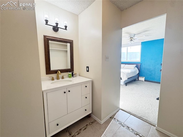 bathroom with a textured ceiling, a baseboard radiator, vanity, a ceiling fan, and baseboards