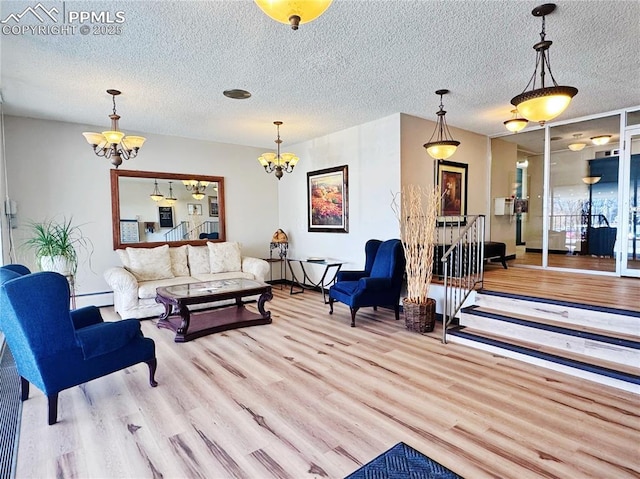 living area featuring a textured ceiling, baseboard heating, wood finished floors, and an inviting chandelier