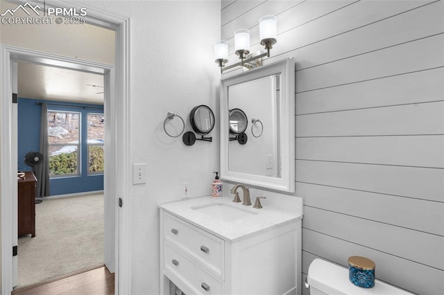 bathroom with toilet, wood finished floors, and vanity