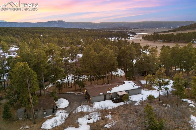 aerial view at dusk with a wooded view and a mountain view