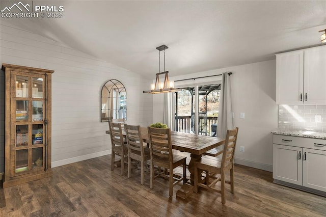 dining room featuring lofted ceiling, a notable chandelier, baseboards, and dark wood-type flooring