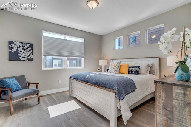 bedroom with baseboards and wood finished floors