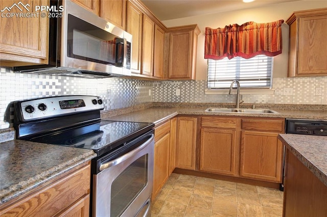 kitchen with stainless steel appliances, brown cabinetry, a sink, and backsplash