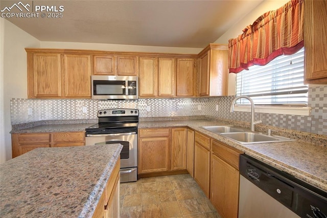 kitchen featuring appliances with stainless steel finishes, backsplash, a sink, and light countertops