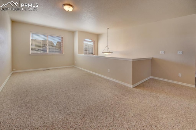 carpeted spare room with baseboards and a textured ceiling