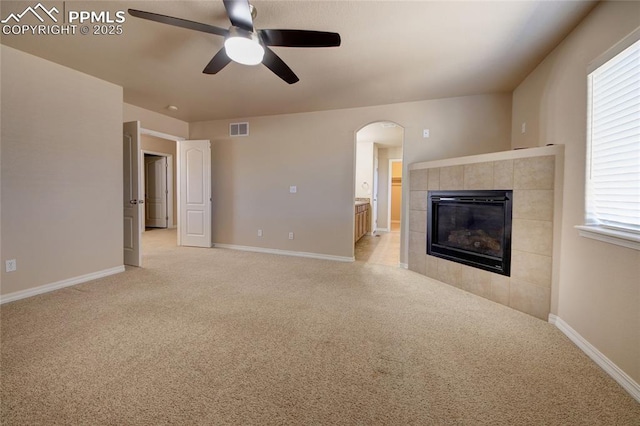 unfurnished living room featuring light colored carpet, visible vents, baseboards, and a tile fireplace