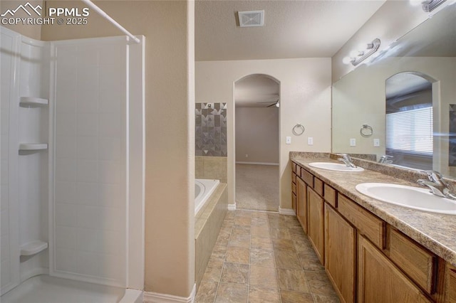 bathroom with double vanity, walk in shower, a sink, and visible vents