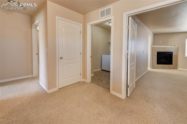 hall featuring washer / dryer, carpet, visible vents, and baseboards